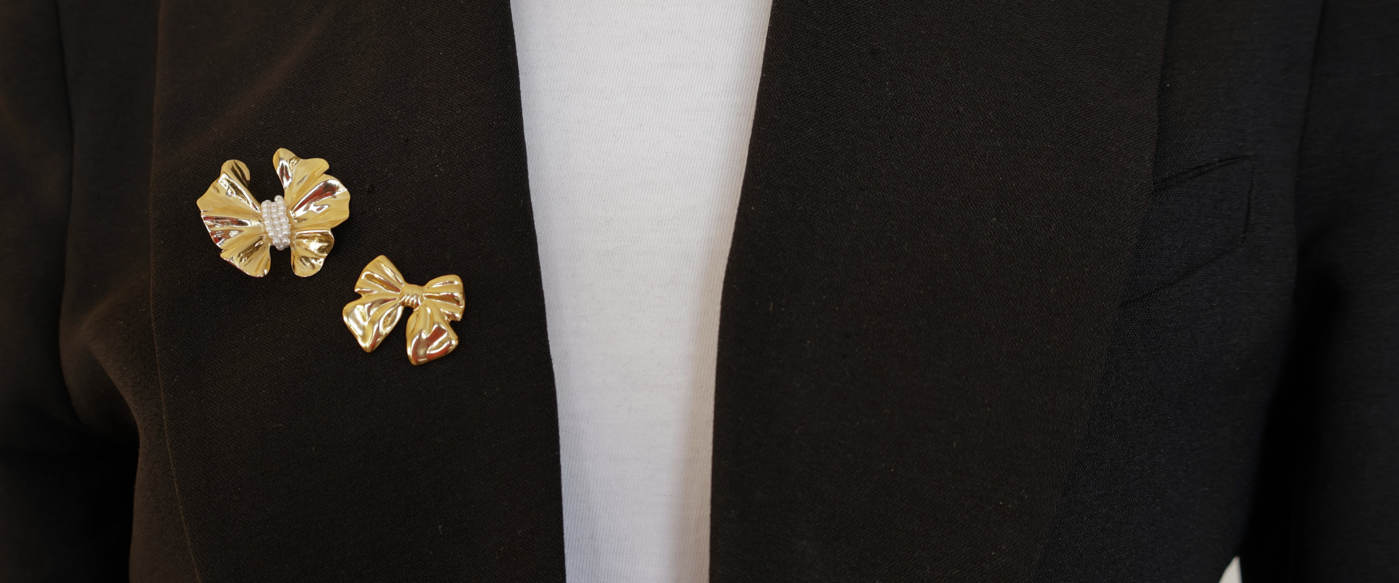 Header_homepagina_pins_op_zwarte_blazer