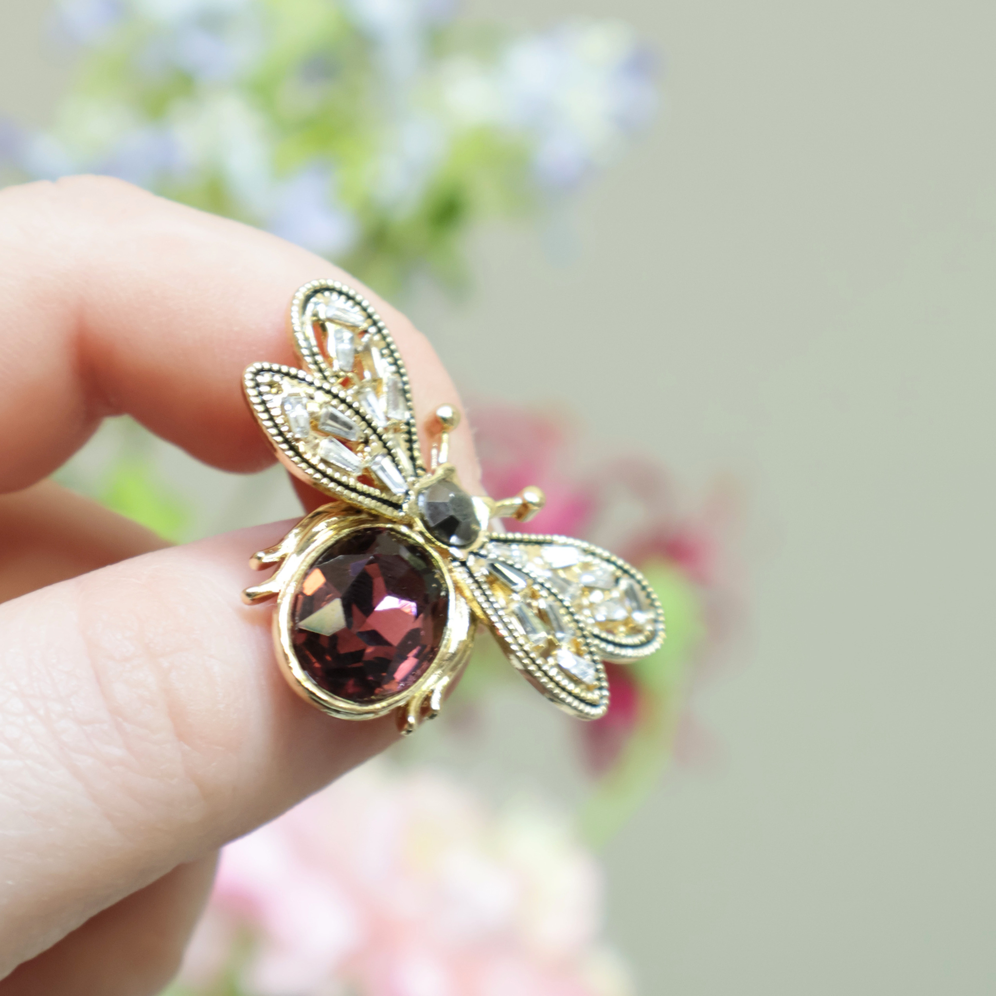 broche vlinder rood met bloemige achtergrond