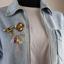10020 gold pin with gold charms and purple fringe 10012 brooch at 20030 gold pin flower on denim jacket