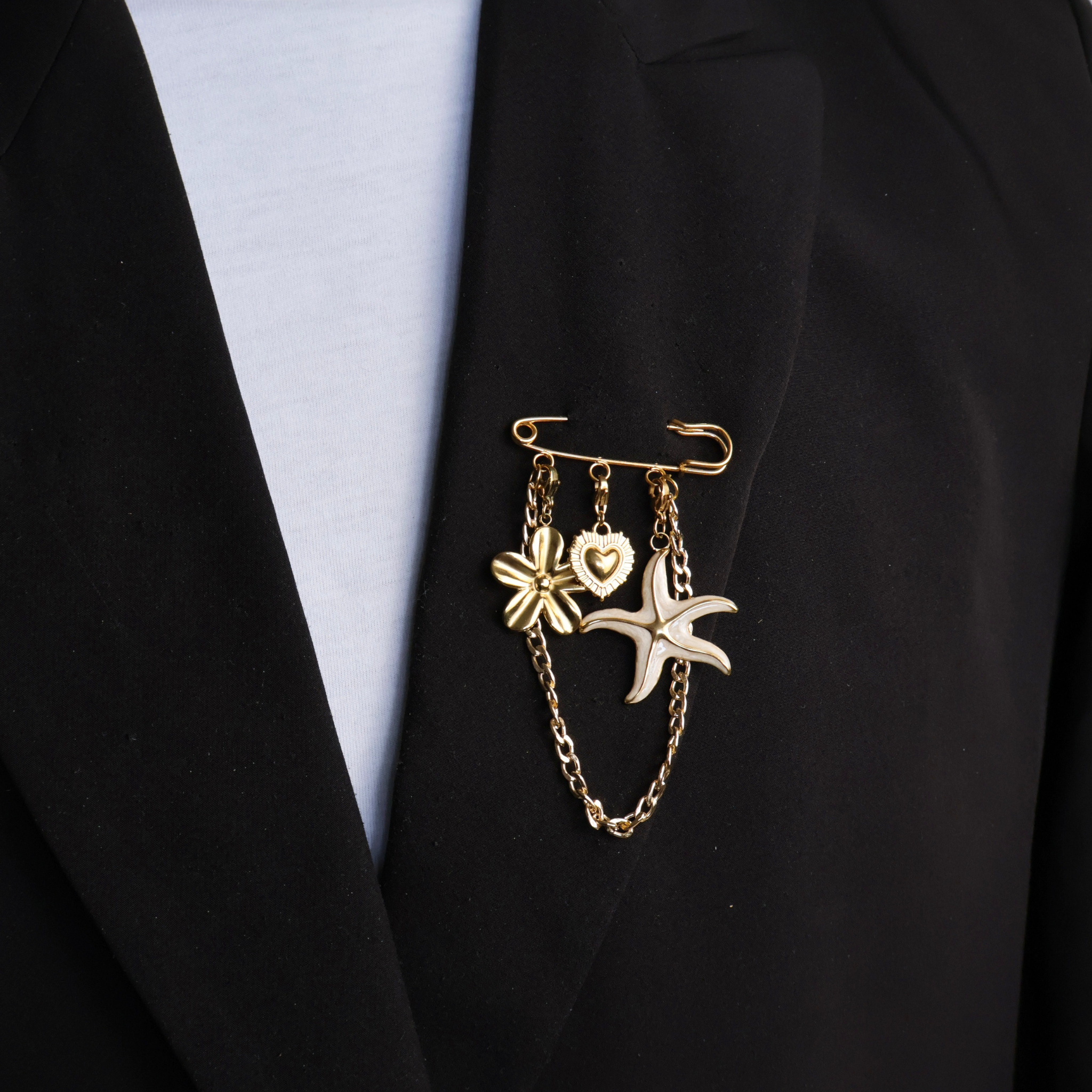 Goldene Sicherheitsnadel mit Blume, Herz, Seestern und Goldkette