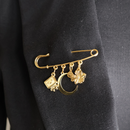 safety pin goud met bedels op zwarte blazer