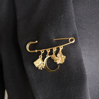 safety pin goud met bedels op zwarte blazer