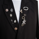 Broches en pins op zwarte blazer